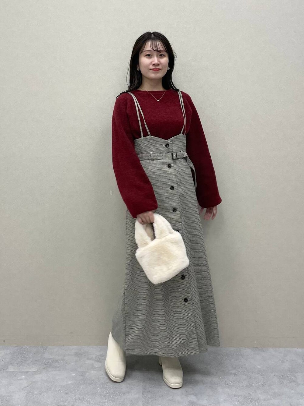 レッド系のニット/セーター、ホワイト系のブーツ、その他のスカートを着用したレディースの秋コーディネートの2枚目の写真