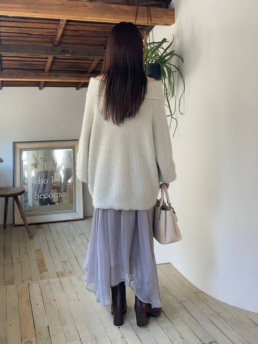 ブラウン系のブーツ、ブルー系のスカート、ホワイト系のショルダーバッグを着用したレディースの冬コーディネートの2枚目の写真