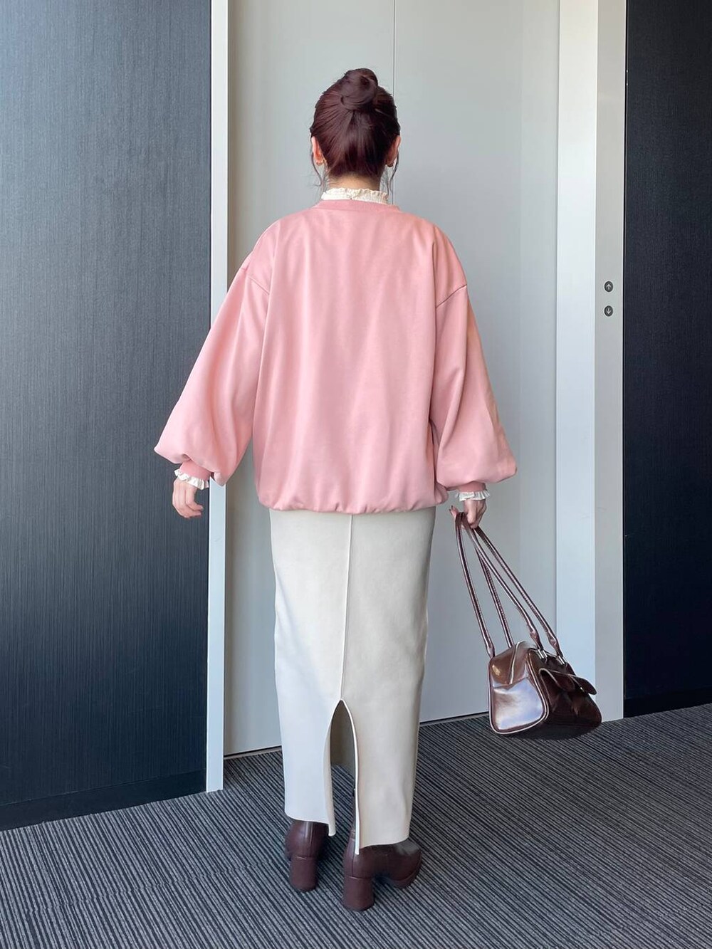 ブラウン系のブーツ、ピンク系のスウェット、ホワイト系のシャツ/ブラウスを着用したレディースの秋コーディネートの2枚目の写真