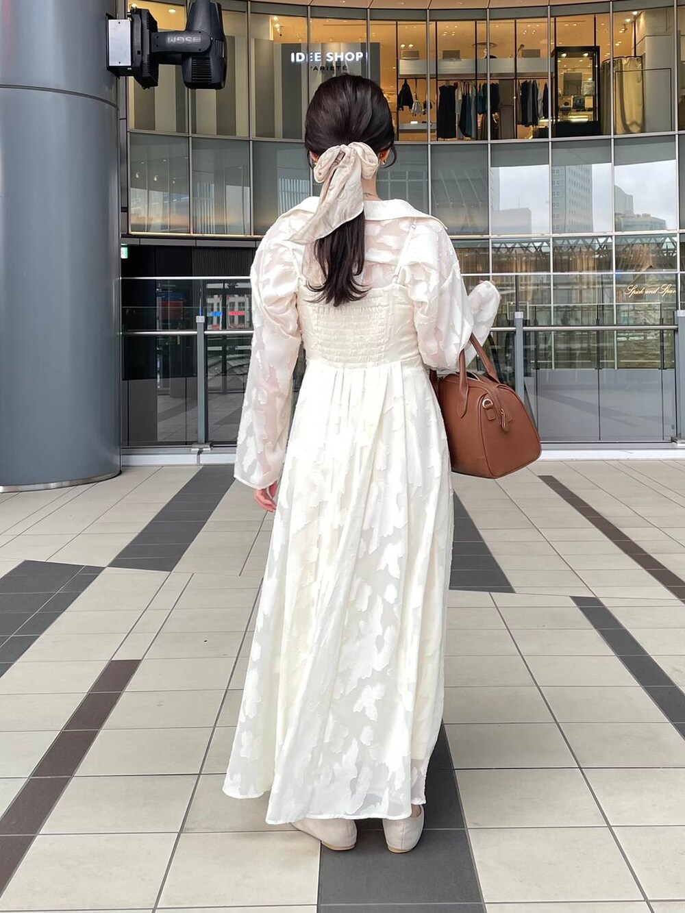 ブラック系のワンピース、ブラウン系のショルダーバッグ、ベージュ系のキーホルダーを着用したレディースの秋コーディネートの2枚目の写真