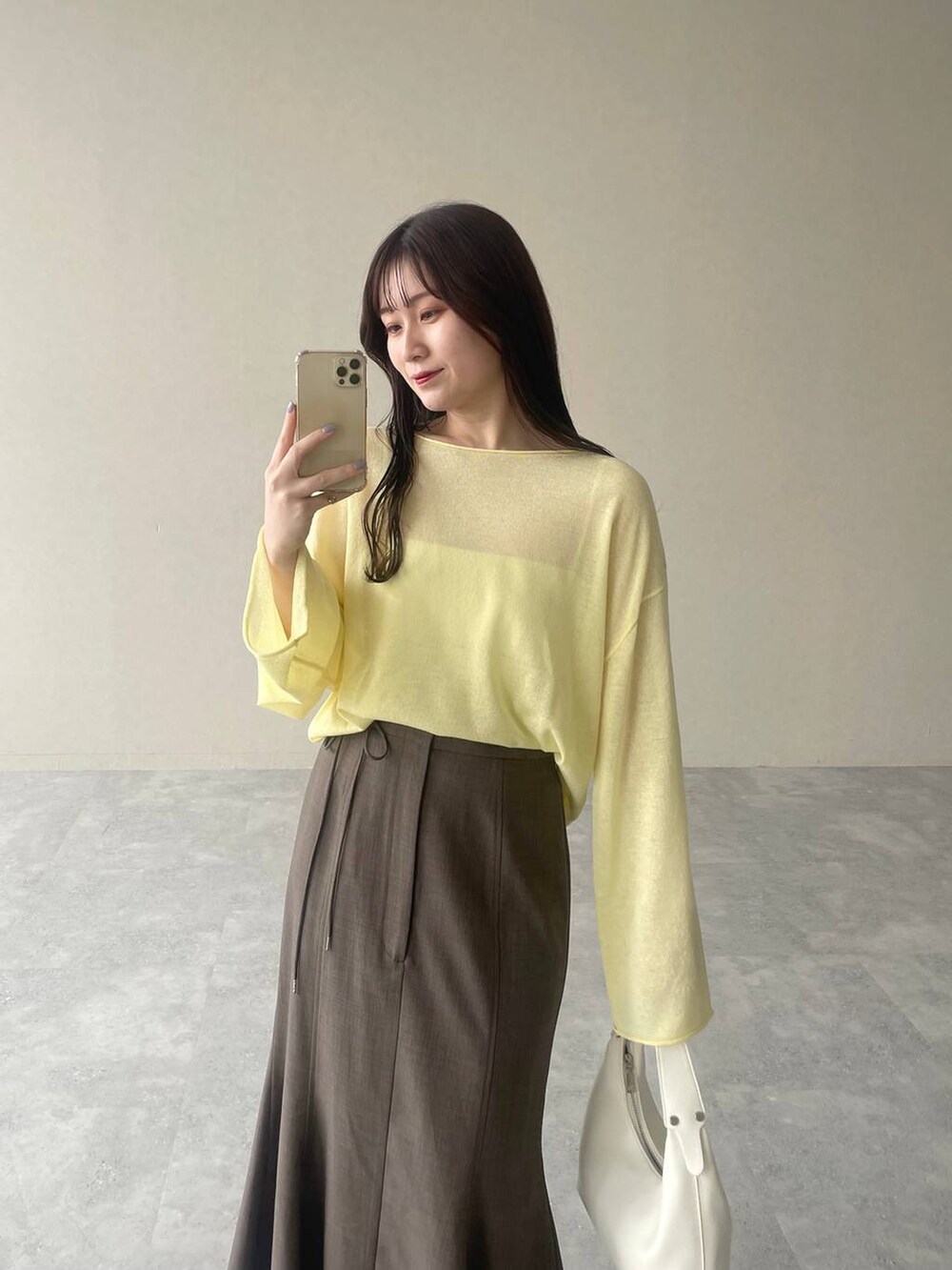 イエロー系のニット/セーター、シルバー系のバレエシューズ、グレー系のスカートを着用したレディースの春コーディネートの3枚目の写真