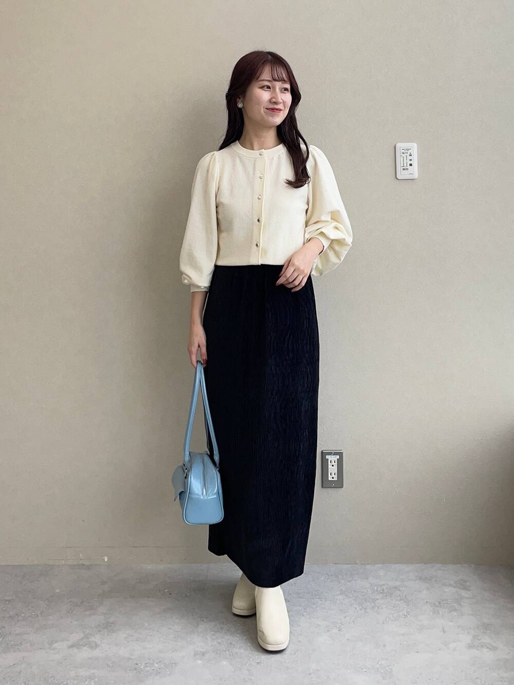 ホワイト系のブルゾン、ホワイト系のブーツ、ブラック系のスカートを着用したレディースの秋コーディネートの7枚目の写真