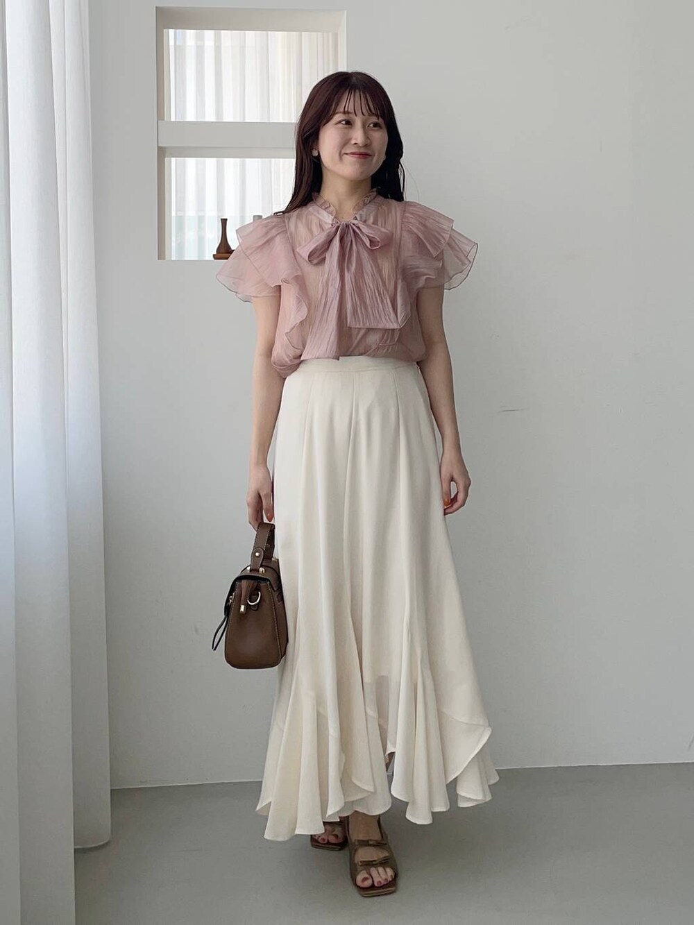 ブラウン系のサンダル、ホワイト系のテーラードジャケット、ピンク系のシャツ/ブラウスを着用したレディースの春コーディネートの3枚目の写真