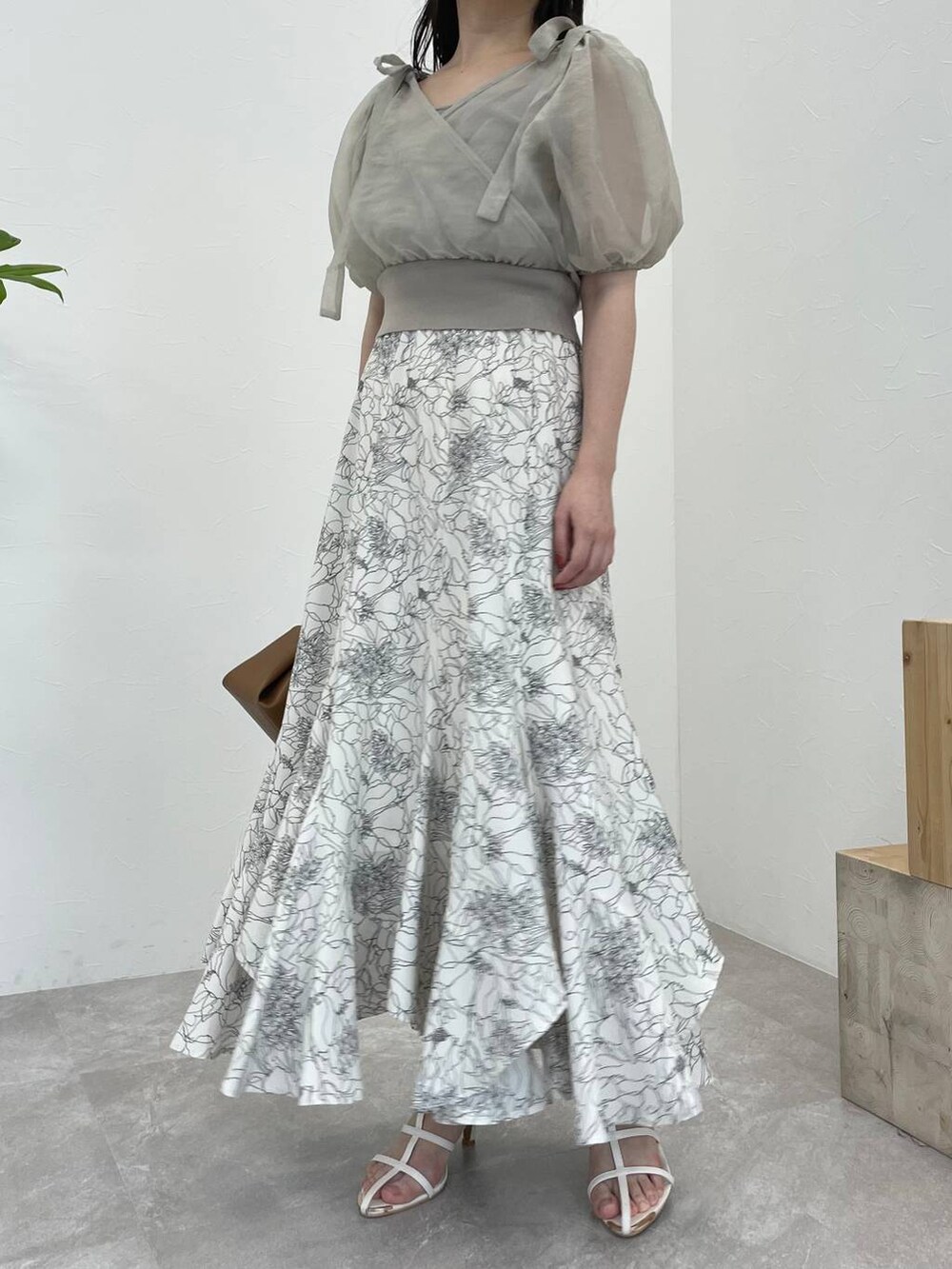 ブラウン系のショルダーバッグ、ホワイト系のスカート、ホワイト系のサンダルを着用したレディースの夏コーディネートの4枚目の写真