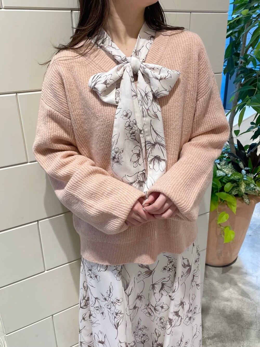 ピンク系のニット/セーター、グレー系のブーツ、ホワイト系のトートバッグを着用したレディースの冬コーディネートの3枚目の写真