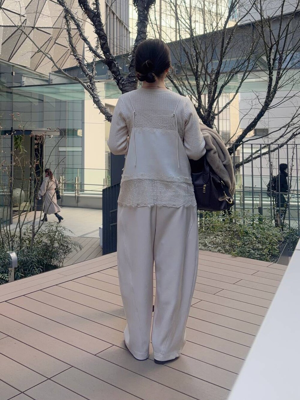 ブラウン系のボストンバッグ、ホワイト系のキャミソール、ホワイト系のその他パンツを着用したレディースの冬コーディネートの5枚目の写真