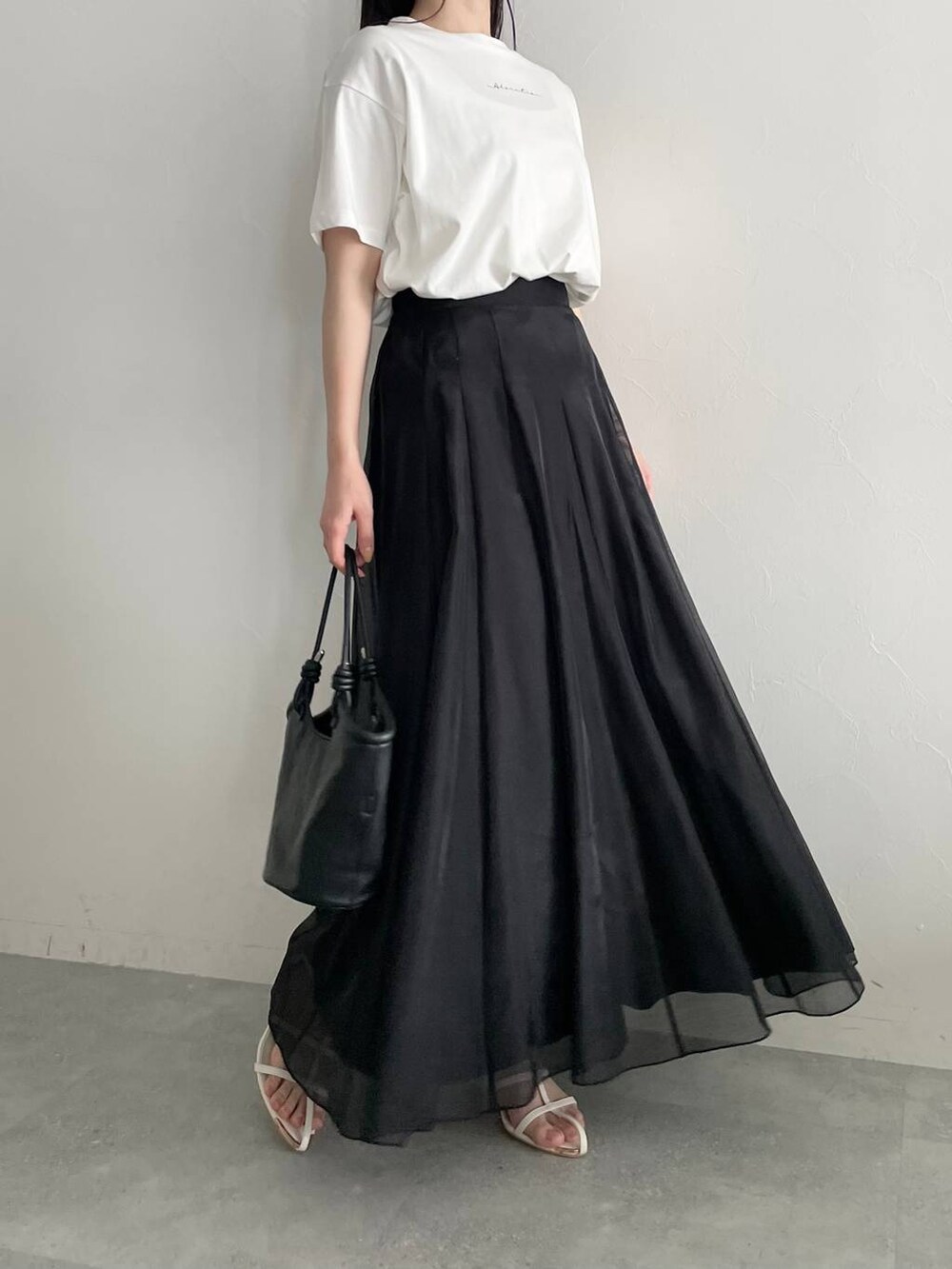 ブラック系のハンドバッグ、ホワイト系のサンダル、ブラック系のスカートを着用したレディースの春コーディネートの5枚目の写真