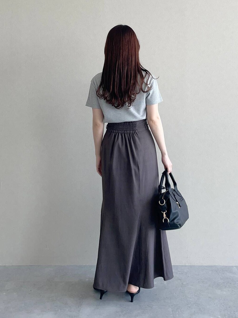 ブラウン系のテーラードジャケット、ブラック系のパンプス、ブラック系のボストンバッグを着用したレディースの春コーディネートの4枚目の写真