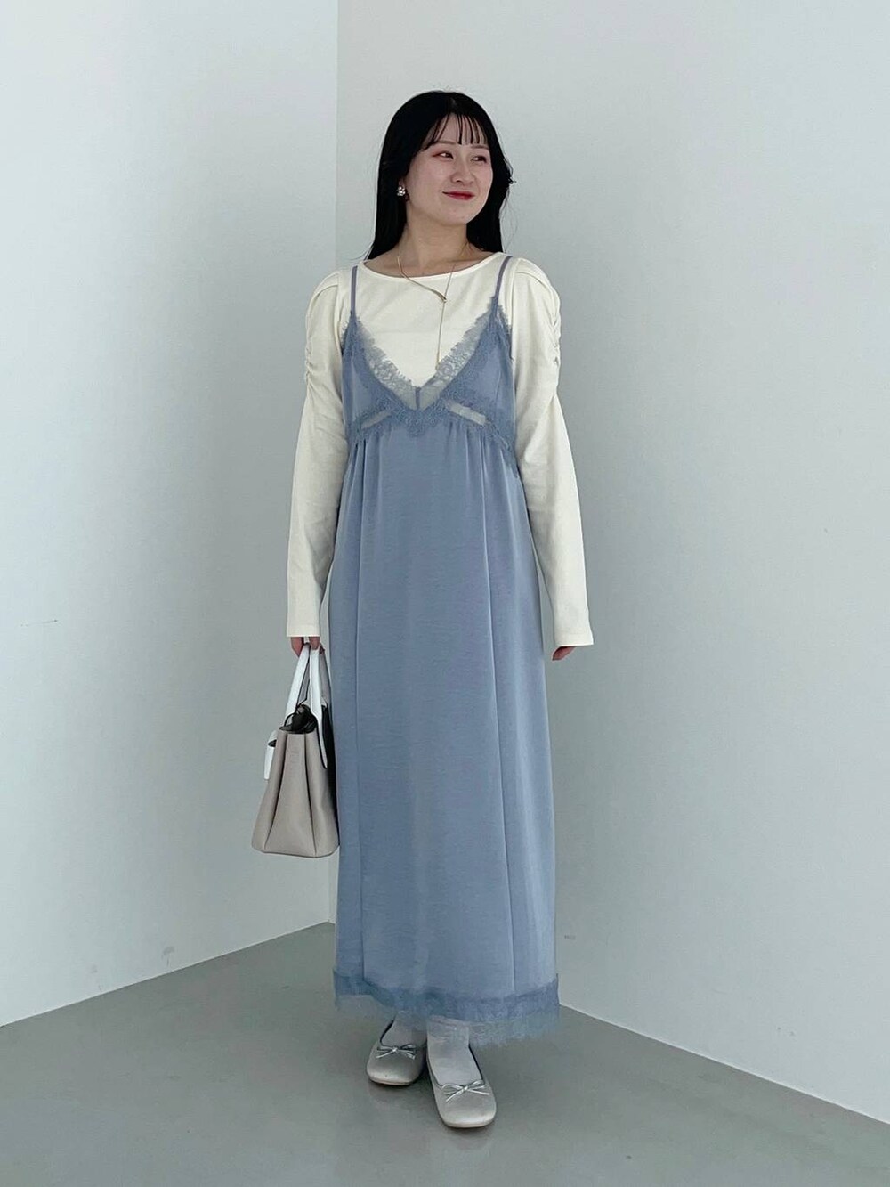 ベージュ系のショルダーバッグ、ホワイト系のマウンテンパーカー、シルバー系のバレエシューズを着用したレディースの春コーディネートの5枚目の写真