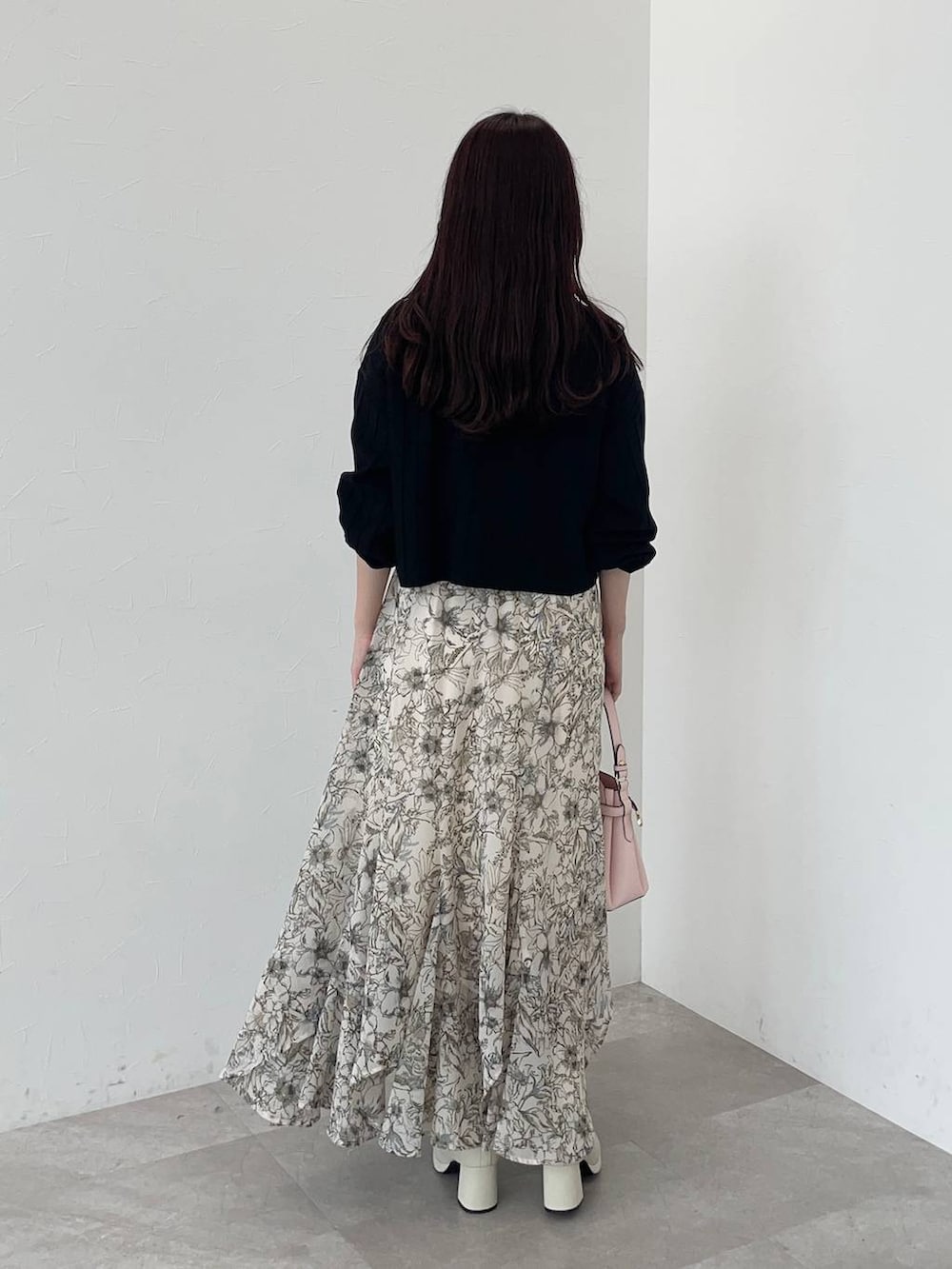 ベージュ系のピーコート、ピンク系のショルダーバッグ、ホワイト系のスカートを着用したレディースの秋コーディネートの5枚目の写真