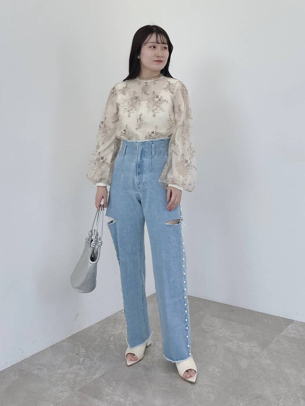 ホワイト系のシャツ/ブラウス、シルバー系のハンドバッグ、ホワイト系のブーツを着用したレディースの冬コーディネートの4枚目の写真