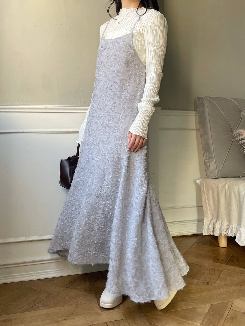 ブラウン系のハンドバッグ、ホワイト系のブーツ、ホワイト系のTシャツ/カットソーを着用したレディースの冬コーディネートの4枚目の写真