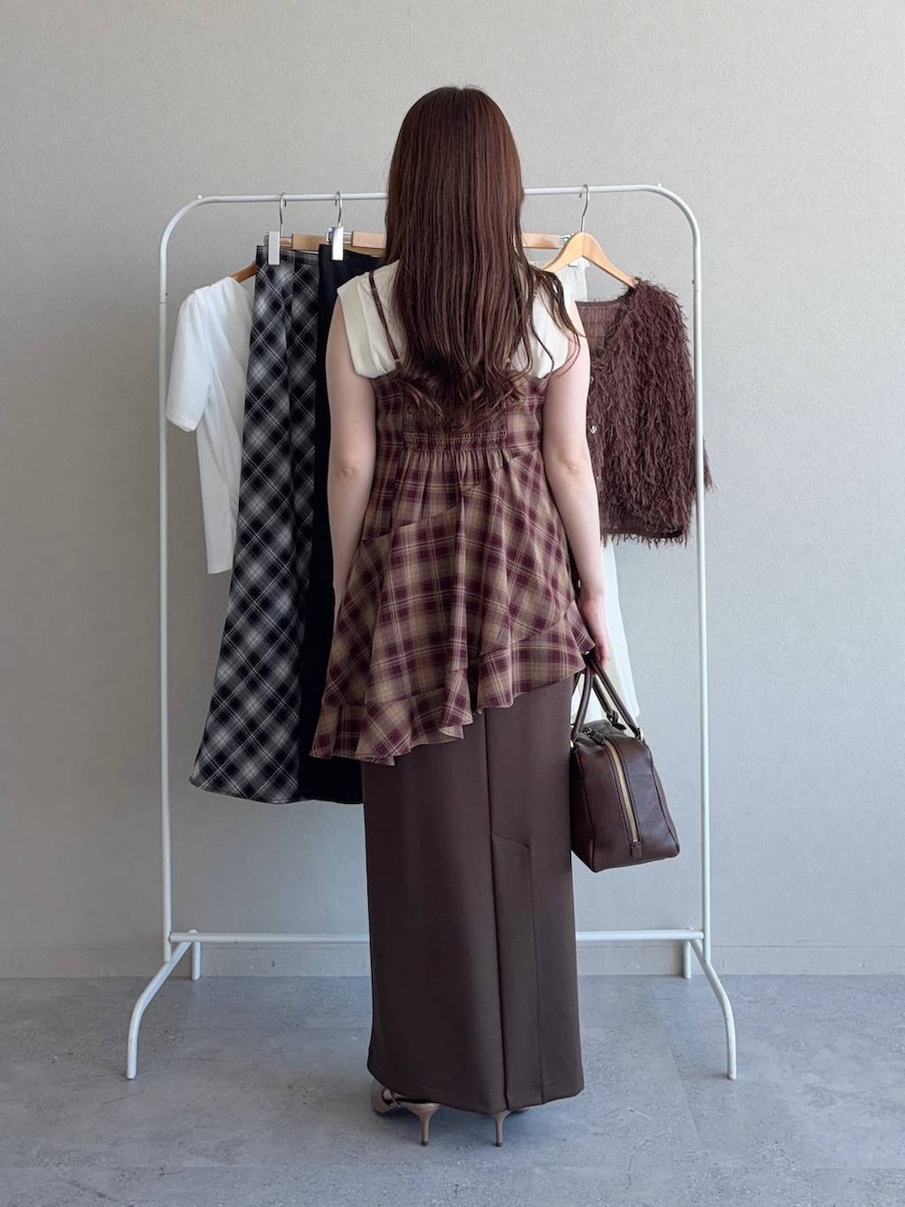 ホワイト系のニット/セーター、ブラウン系のスカート、レッド系のシャツ/ブラウスを着用したレディースの秋コーディネートの2枚目の写真