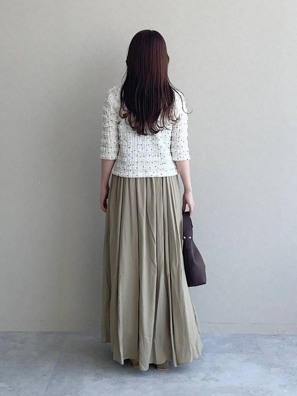 ブラウン系のサンダル、ブラウン系のショルダーバッグ、ベージュ系のワンピースを着用したレディースの夏コーディネートの2枚目の写真