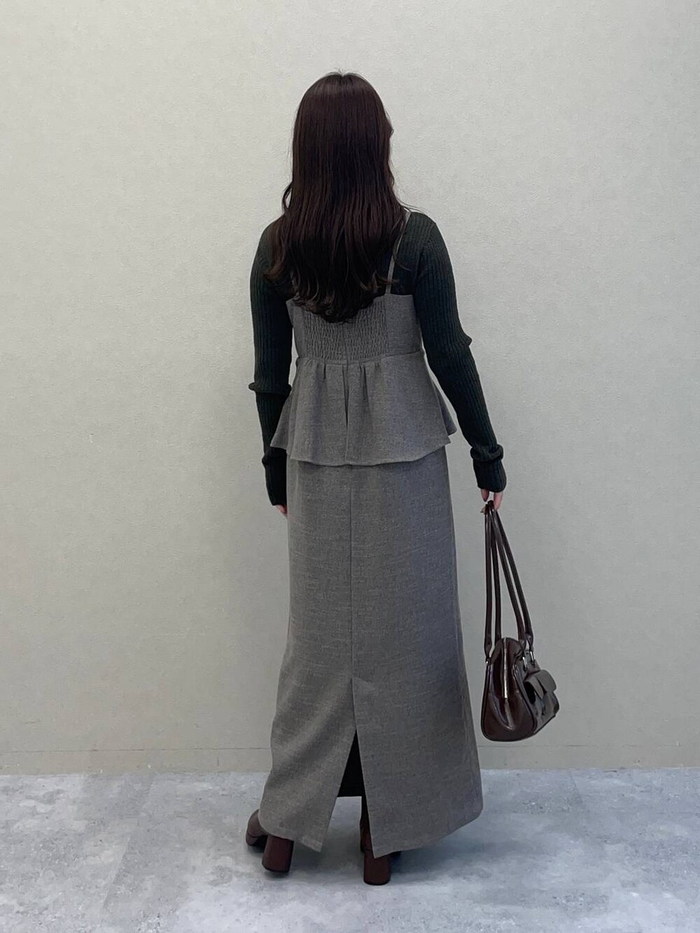 ベージュ系のピーコート、ブラウン系のブーツ、グレー系のワンピースを着用したレディースの秋コーディネートの4枚目の写真