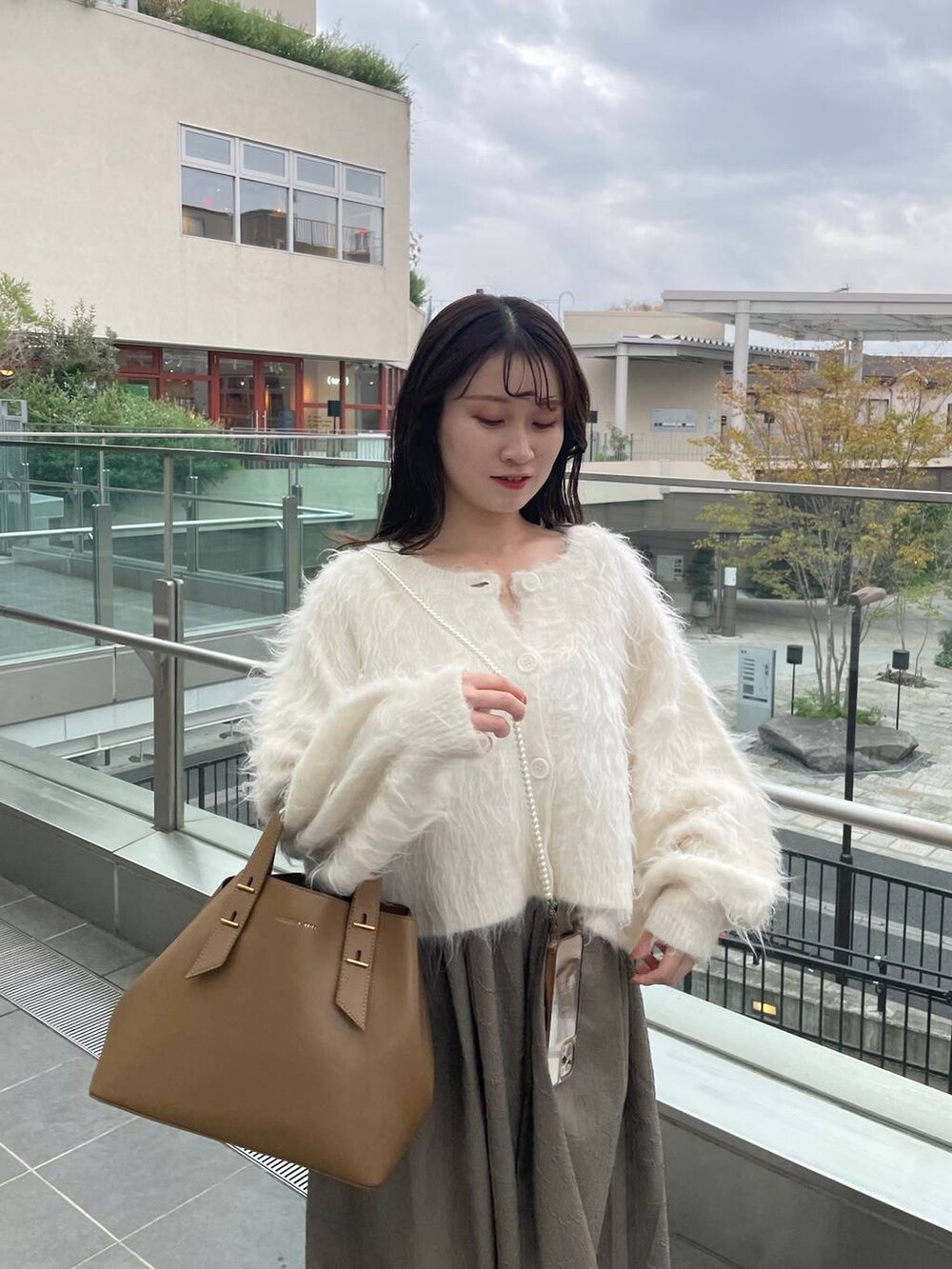 グリーン系のTシャツ/カットソー、ホワイト系のカーディガン/ボレロを着用したレディースの秋コーディネートの3枚目の写真