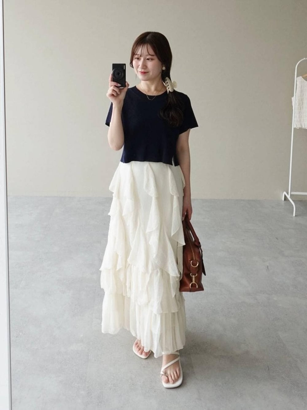 ブルー系のニット/セーター、ホワイト系のスカート、ブラウン系のボストンバッグを着用したレディースの夏コーディネートの3枚目の写真