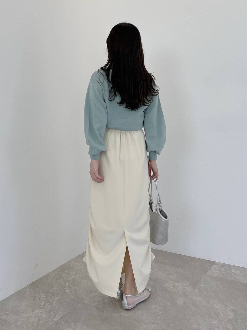 シルバー系のバレエシューズ、グリーン系のニット/セーター、ブラック系のトレンチコートを着用したレディースの冬コーディネートの5枚目の写真