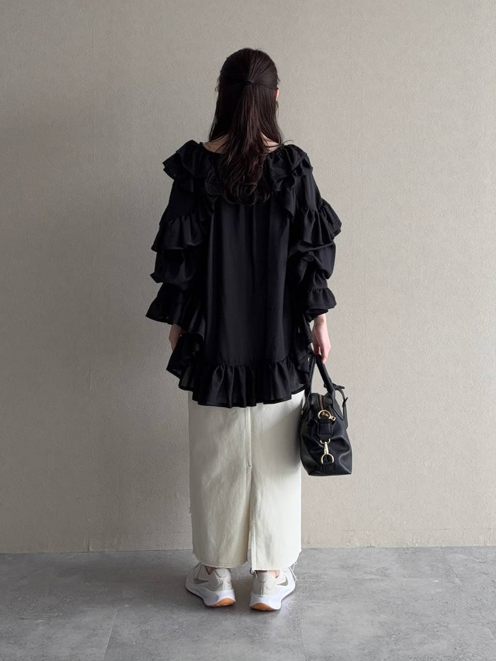 ブラック系のボストンバッグ、ブラック系のシャツ/ブラウス、ホワイト系のスカートを着用したレディースの春コーディネートの2枚目の写真