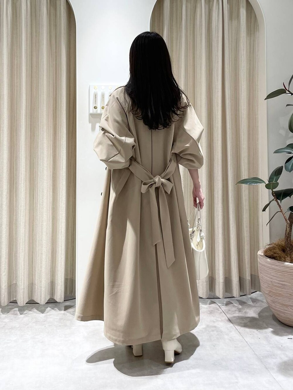 ベージュ系のTシャツ/カットソー、ホワイト系のハンドバッグ、ホワイト系のブーツを着用したレディースの春コーディネートの2枚目の写真