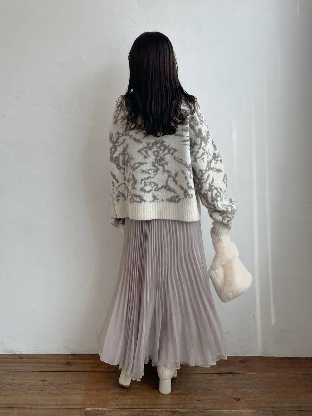 ホワイト系のブーツ、ホワイト系のハンドバッグ、ベージュ系のスカートを着用したレディースの冬コーディネートの2枚目の写真