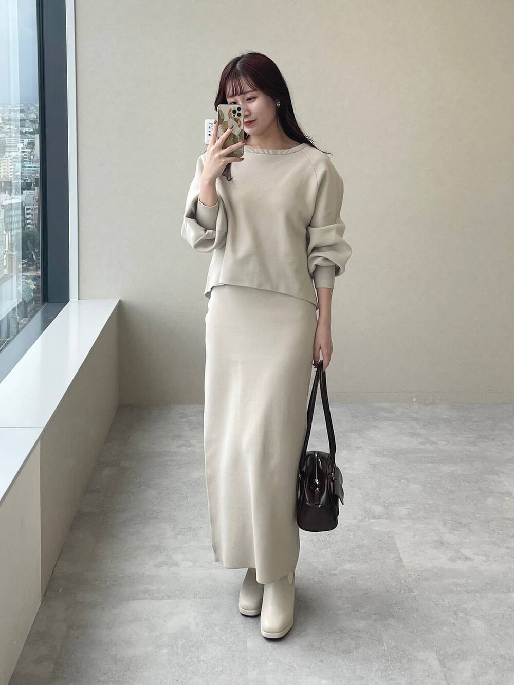 ホワイト系のブーツ、ホワイト系のニット/セーター、ホワイト系のスカートを着用したレディースの秋コーディネートの7枚目の写真