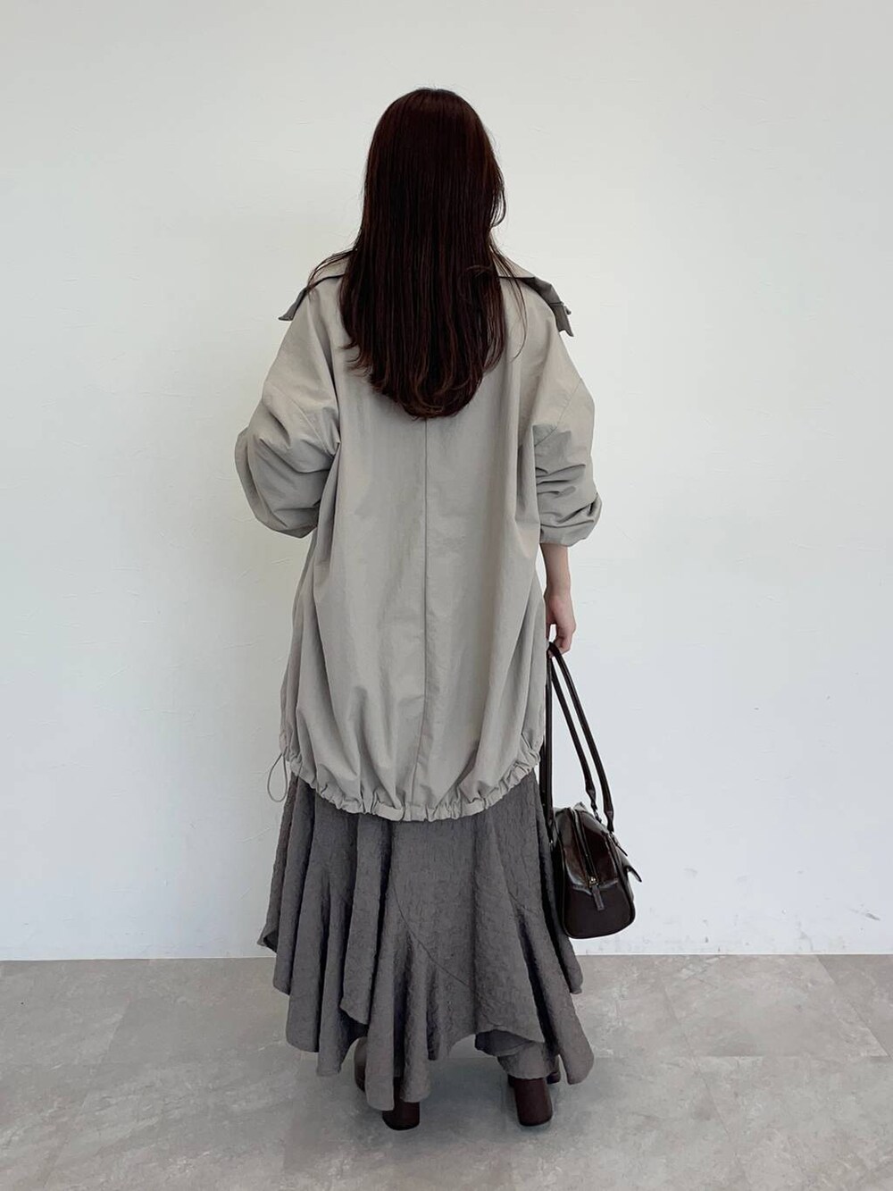 ブラウン系のブーツ、ホワイト系のスウェット、ブラウン系のスカートを着用したレディースの秋コーディネートの2枚目の写真