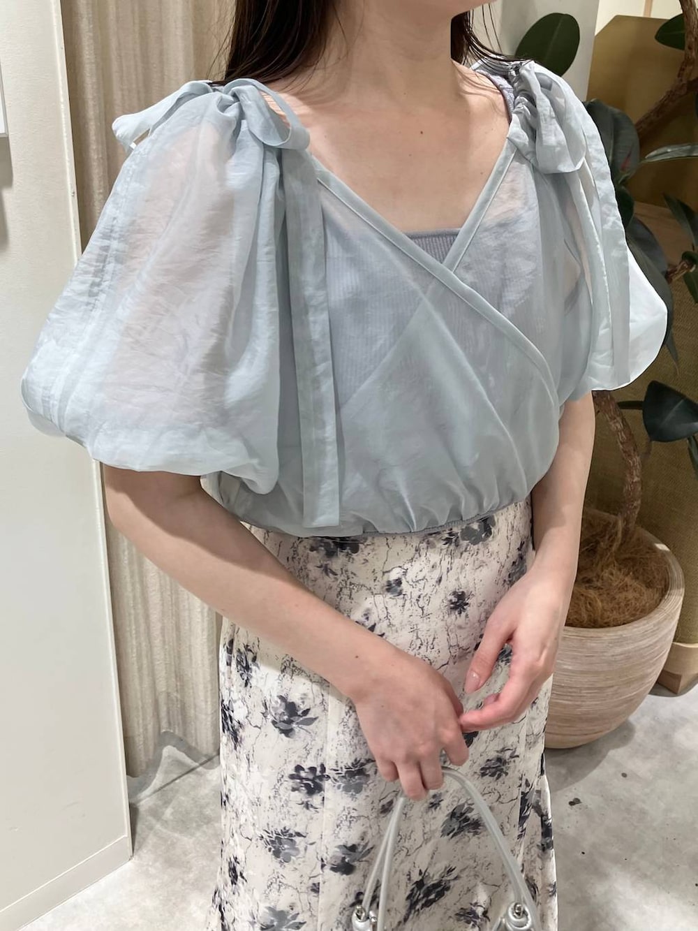 シルバー系のハンドバッグ、ホワイト系のサンダル、ホワイト系のスカートを着用したレディースの春コーディネートの3枚目の写真