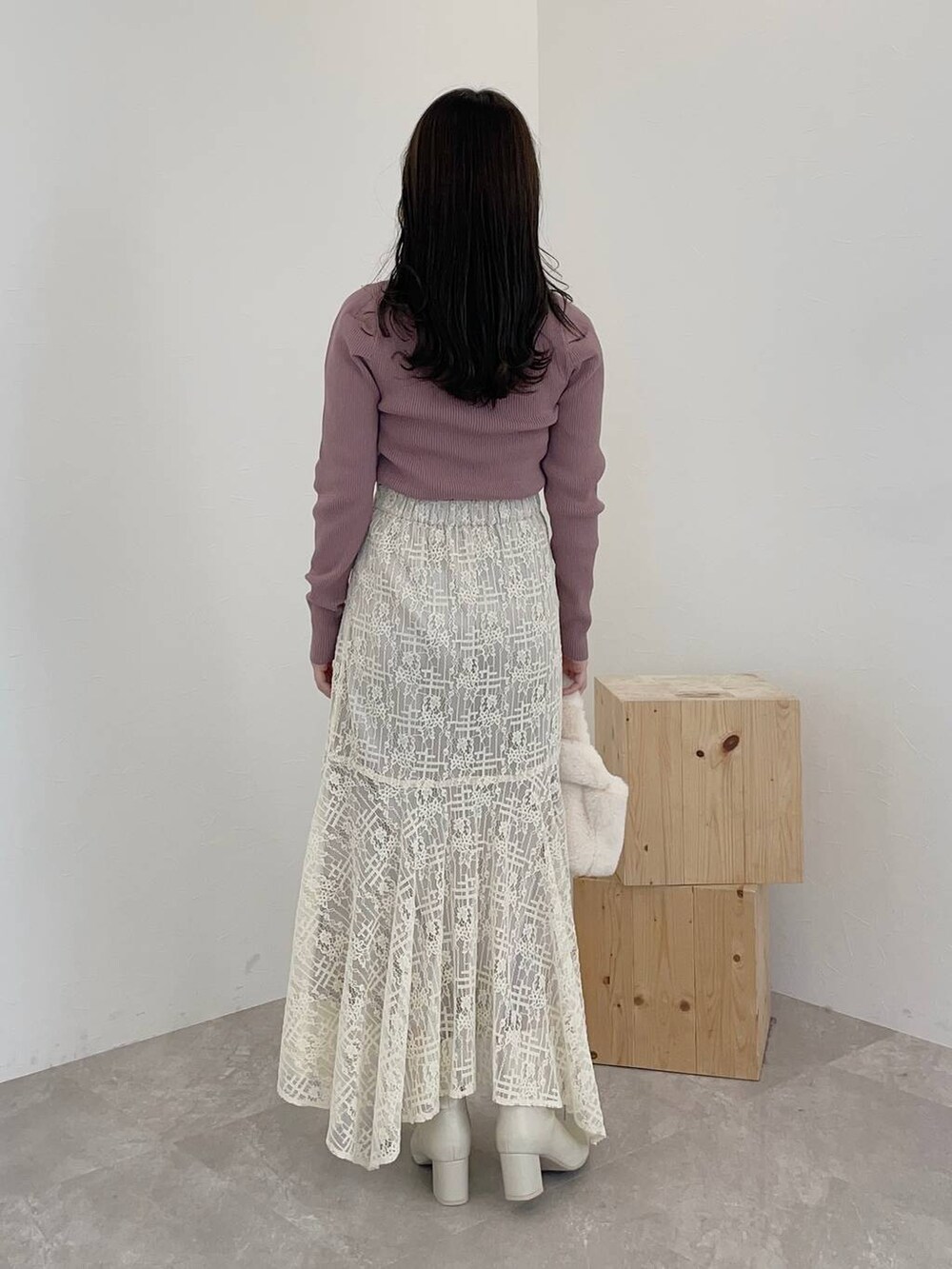 ホワイト系のブーツ、ホワイト系のスカート、ホワイト系のハンドバッグを着用したレディースの秋コーディネートの4枚目の写真