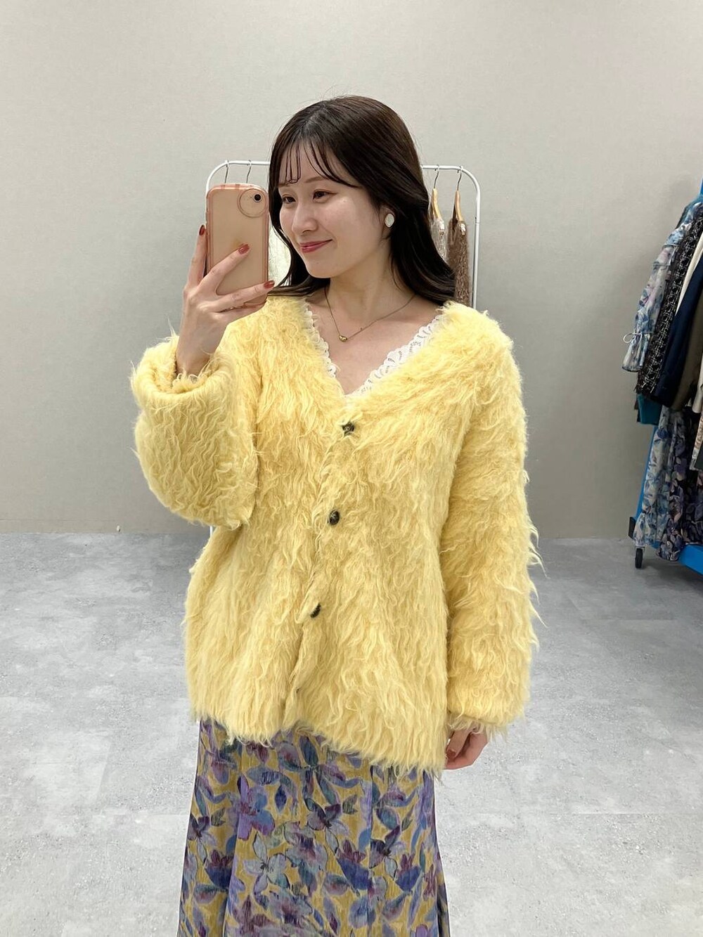 ホワイト系のタンクトップ、イエロー系のカーディガン/ボレロ、イエロー系のスカートを着用したレディースの秋コーディネートの2枚目の写真