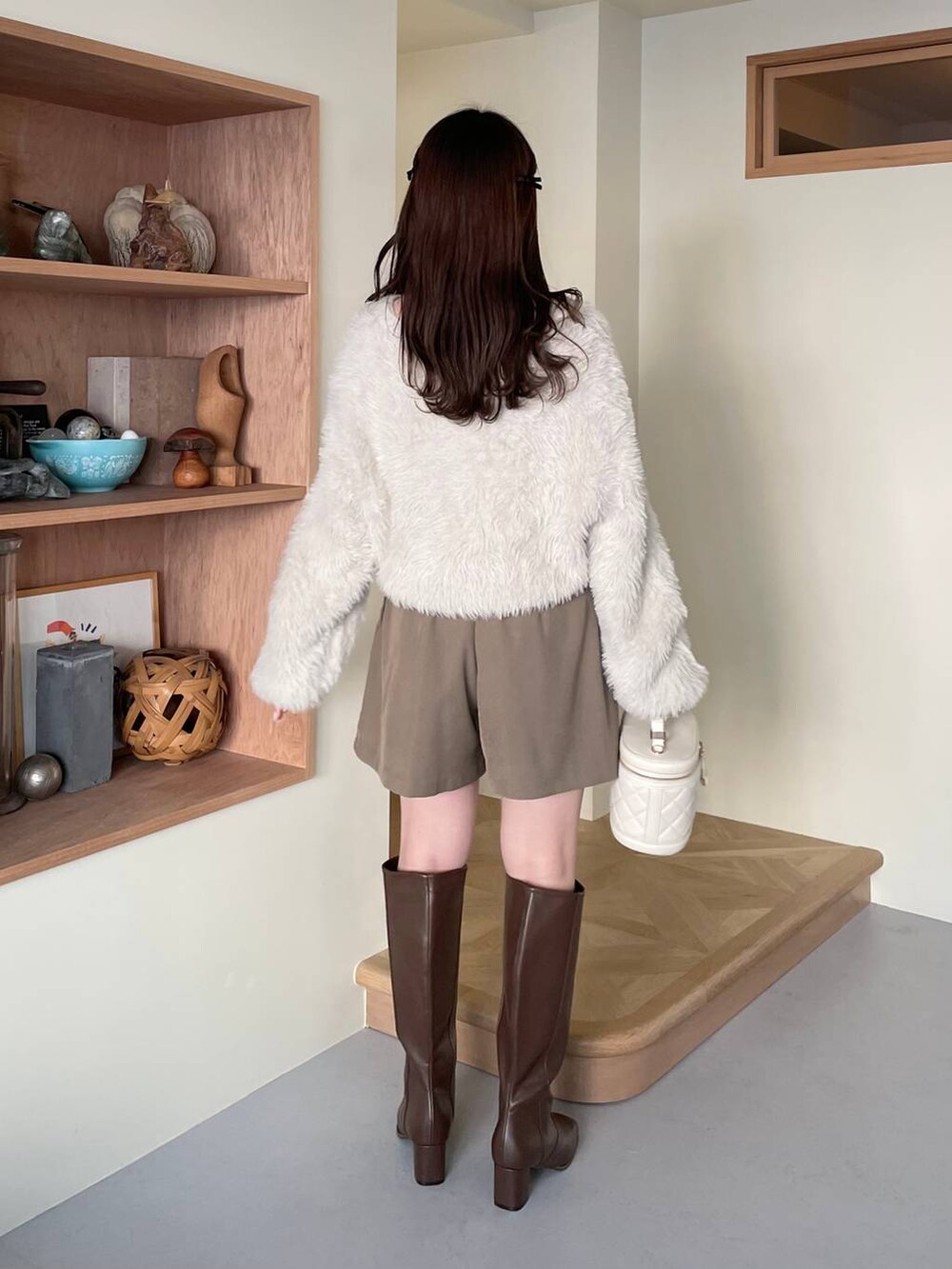 ブラウン系のその他パンツ、ブラウン系のブーツ、ホワイト系のショルダーバッグを着用したレディースの冬コーディネートの3枚目の写真