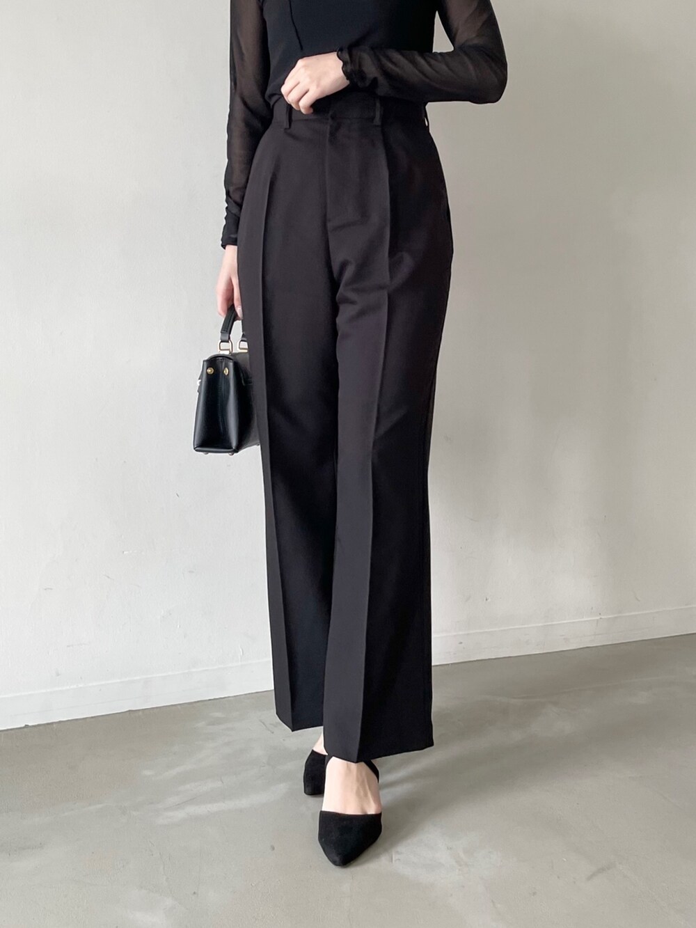 ブラック系のTシャツ/カットソー、ブラック系のその他トップス、ブラック系のスラックスを着用したレディースの春コーディネートの4枚目の写真