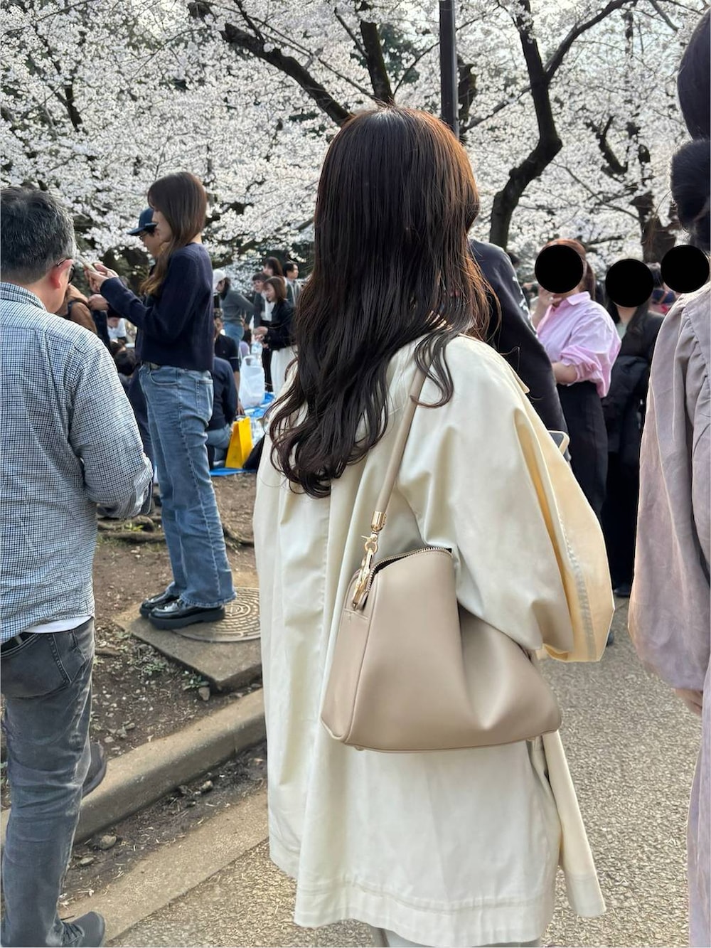 ゴールド系のボストンバッグ、ブラウン系のキャミソール、ホワイト系のスマホグッズを着用したレディースの春コーディネートの4枚目の写真