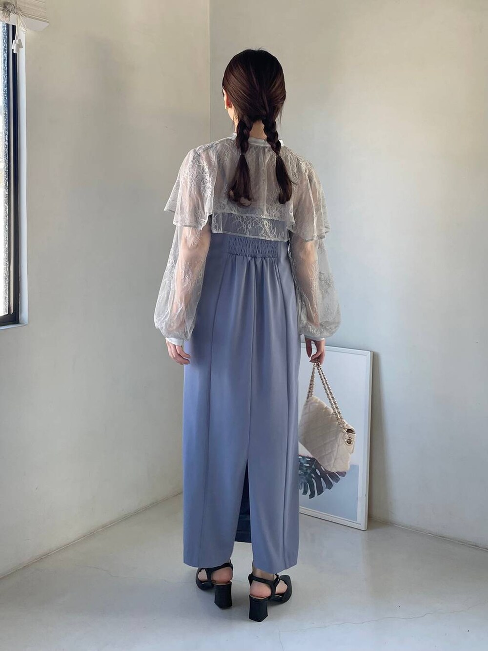 ブルー系のドレス、ホワイト系のショルダーバッグ、ブラック系のパンプスを着用したレディースの冬コーディネートの2枚目の写真