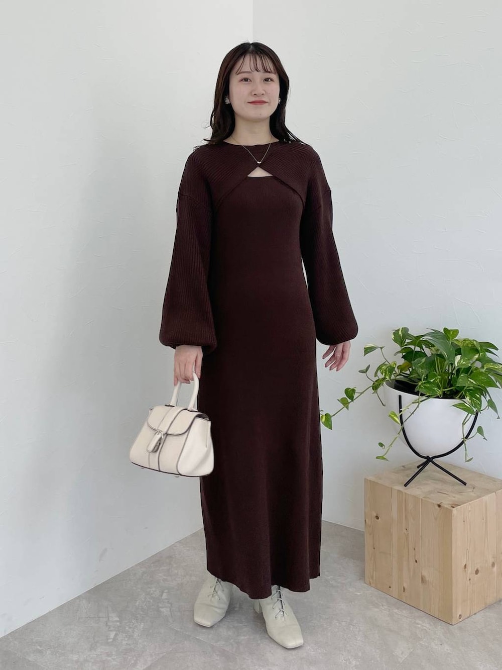 ホワイト系のその他アウター、ホワイト系のハンドバッグ、ホワイト系のブーツを着用したレディースの冬コーディネートの8枚目の写真