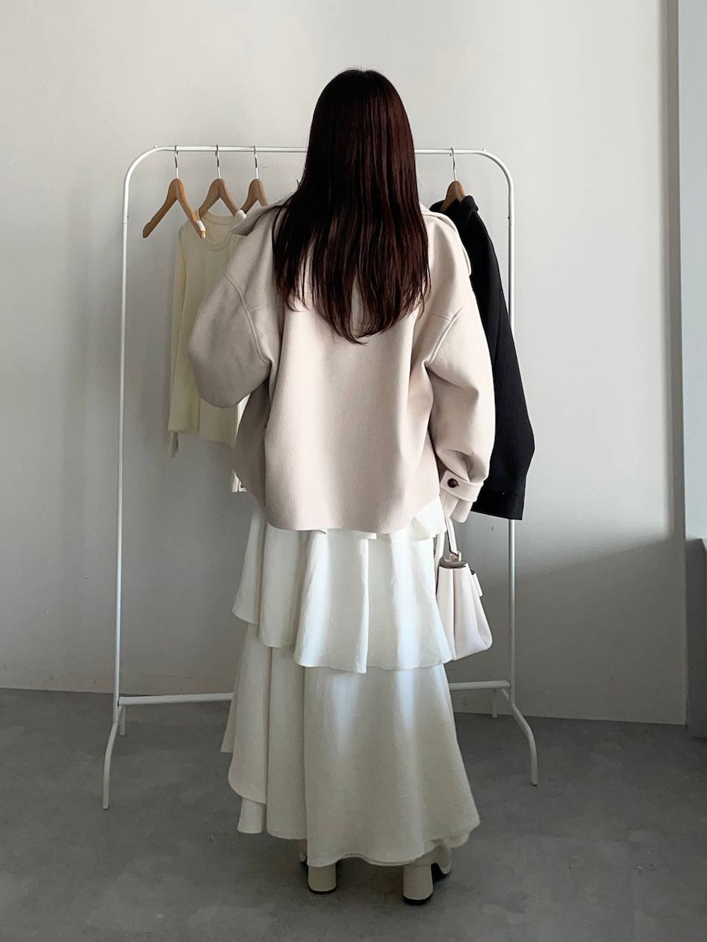 ホワイト系のピーコート、ホワイト系のブーツ、ホワイト系のスカートを着用したレディースの冬コーディネートの2枚目の写真