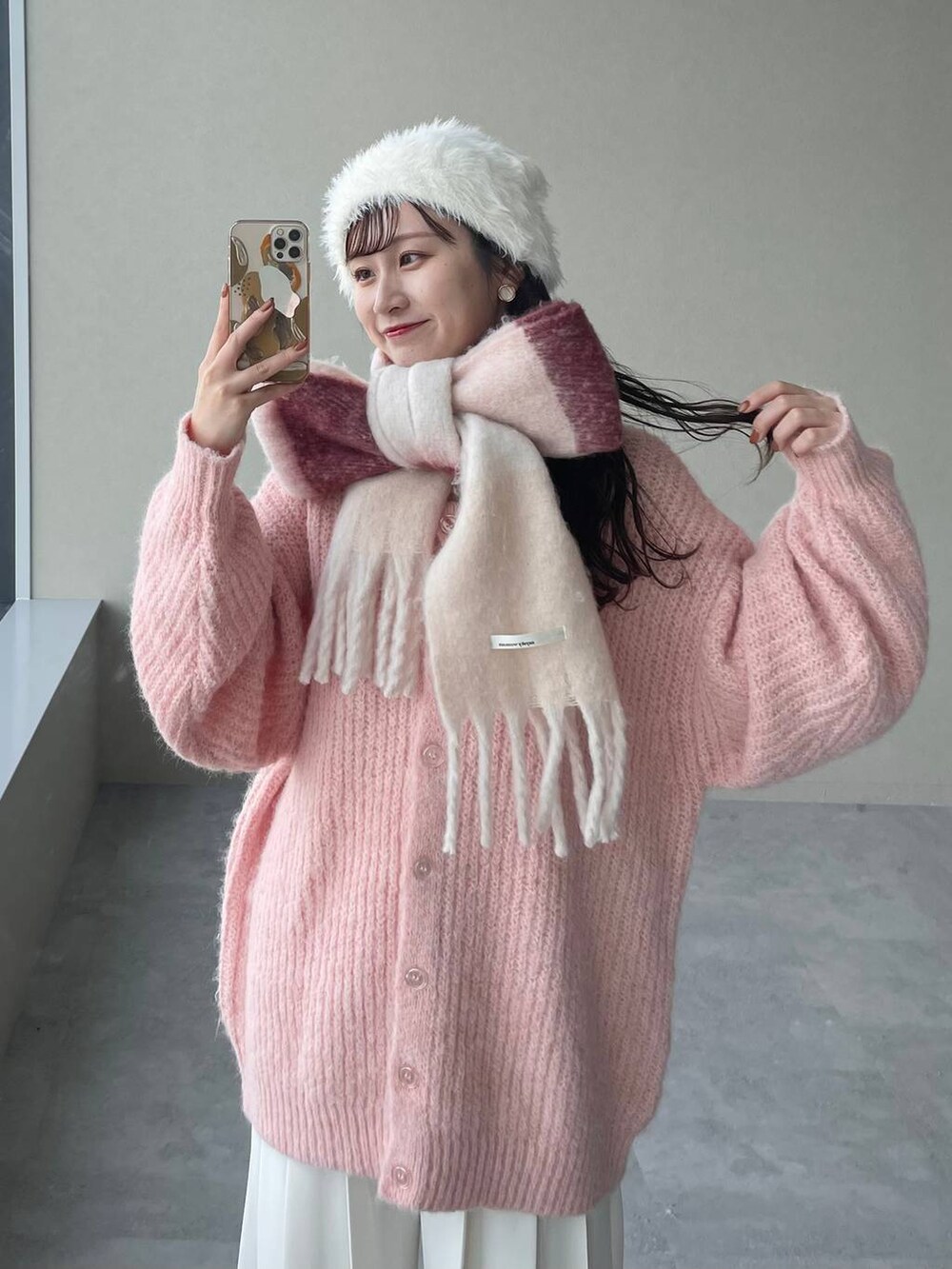 ブラウン系のブーツ、ピンク系のカーディガン/ボレロ、ブラウン系のハンドバッグを着用したレディースの秋コーディネートの3枚目の写真