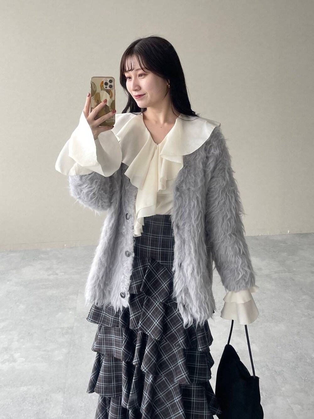 ホワイト系のシャツ/ブラウス、グレー系のカーディガン/ボレロ、ブラウン系のスカートを着用したレディースの秋コーディネートの3枚目の写真