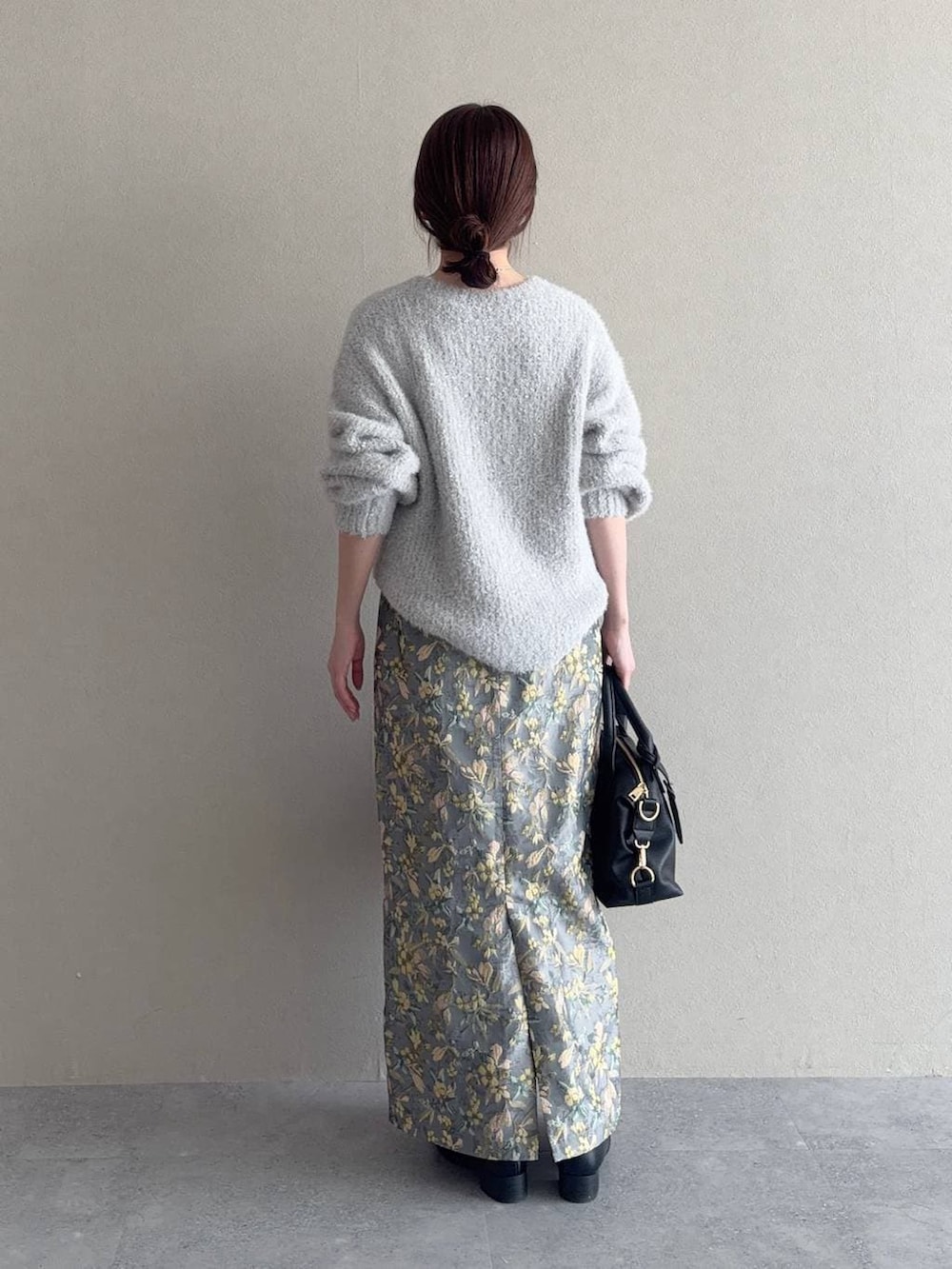 ブラック系のボストンバッグ、ブラック系のローファー、グレー系のニット/セーターを着用したレディースの冬コーディネートの2枚目の写真