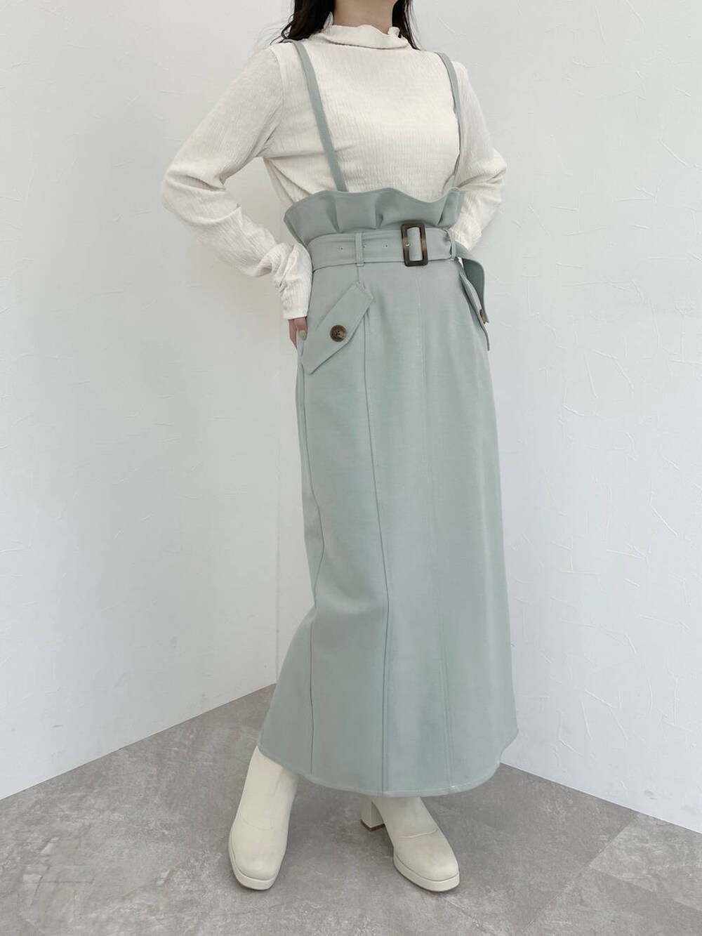 ホワイト系のブーツ、ホワイト系のハンドバッグ、ホワイト系のチェスターコートを着用したレディースの冬コーディネートの7枚目の写真