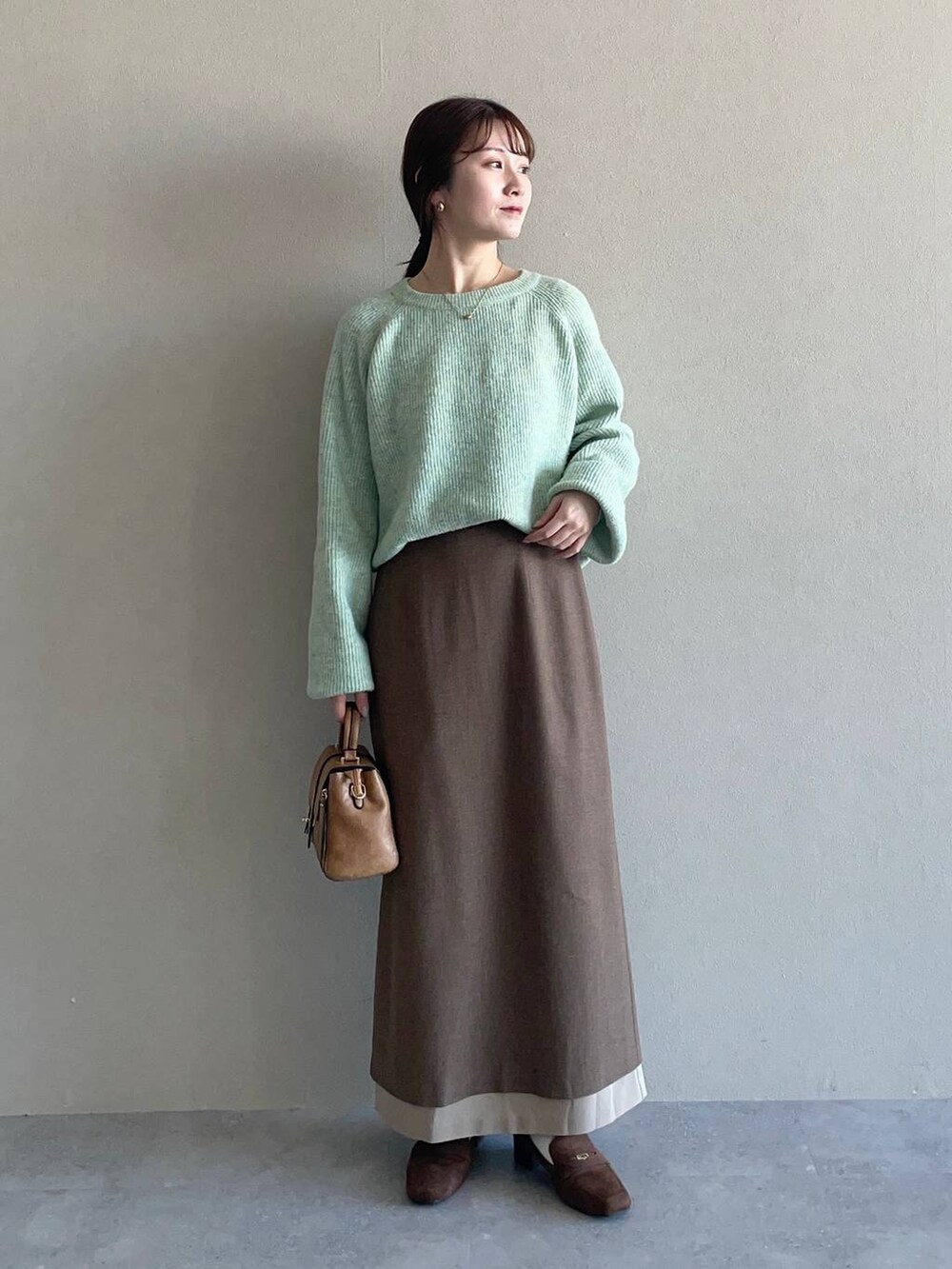 グリーン系のニット/セーター、ブラウン系のローファー、ブラウン系のブルゾンを着用したレディースの冬コーディネートの3枚目の写真