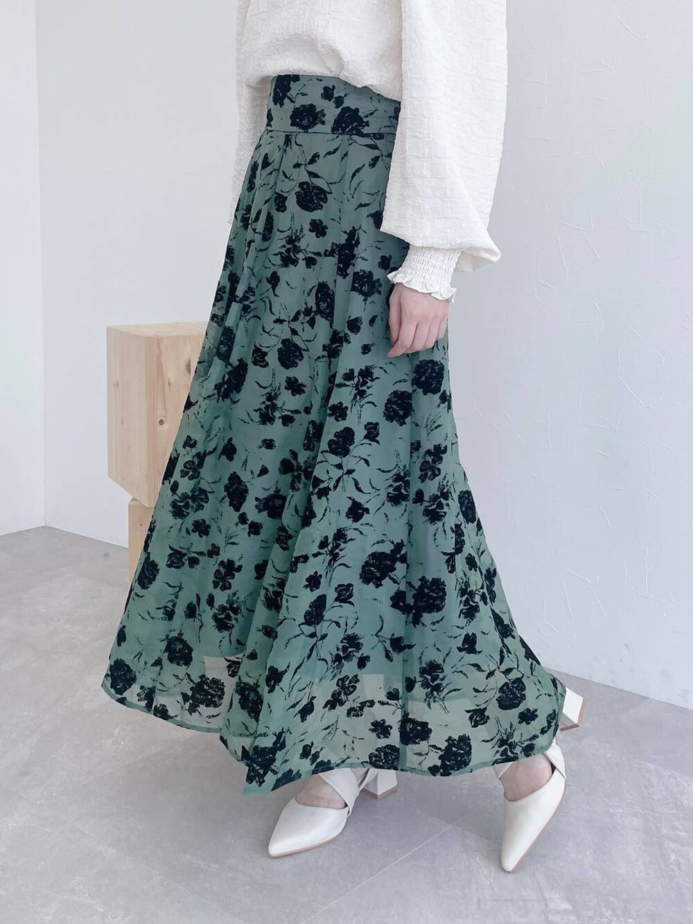 ホワイト系のハンドバッグ、ベージュ系のスカート、ホワイト系のパンプスを着用したレディースの夏コーディネートの5枚目の写真