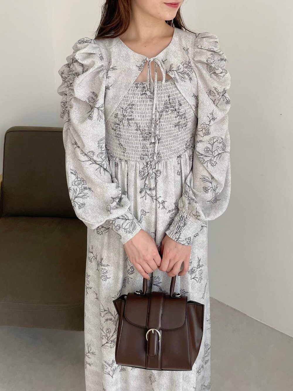 ブラウン系のハンドバッグ、ホワイト系のブーツ、ホワイト系のワンピースを着用したレディースの夏コーディネートの3枚目の写真