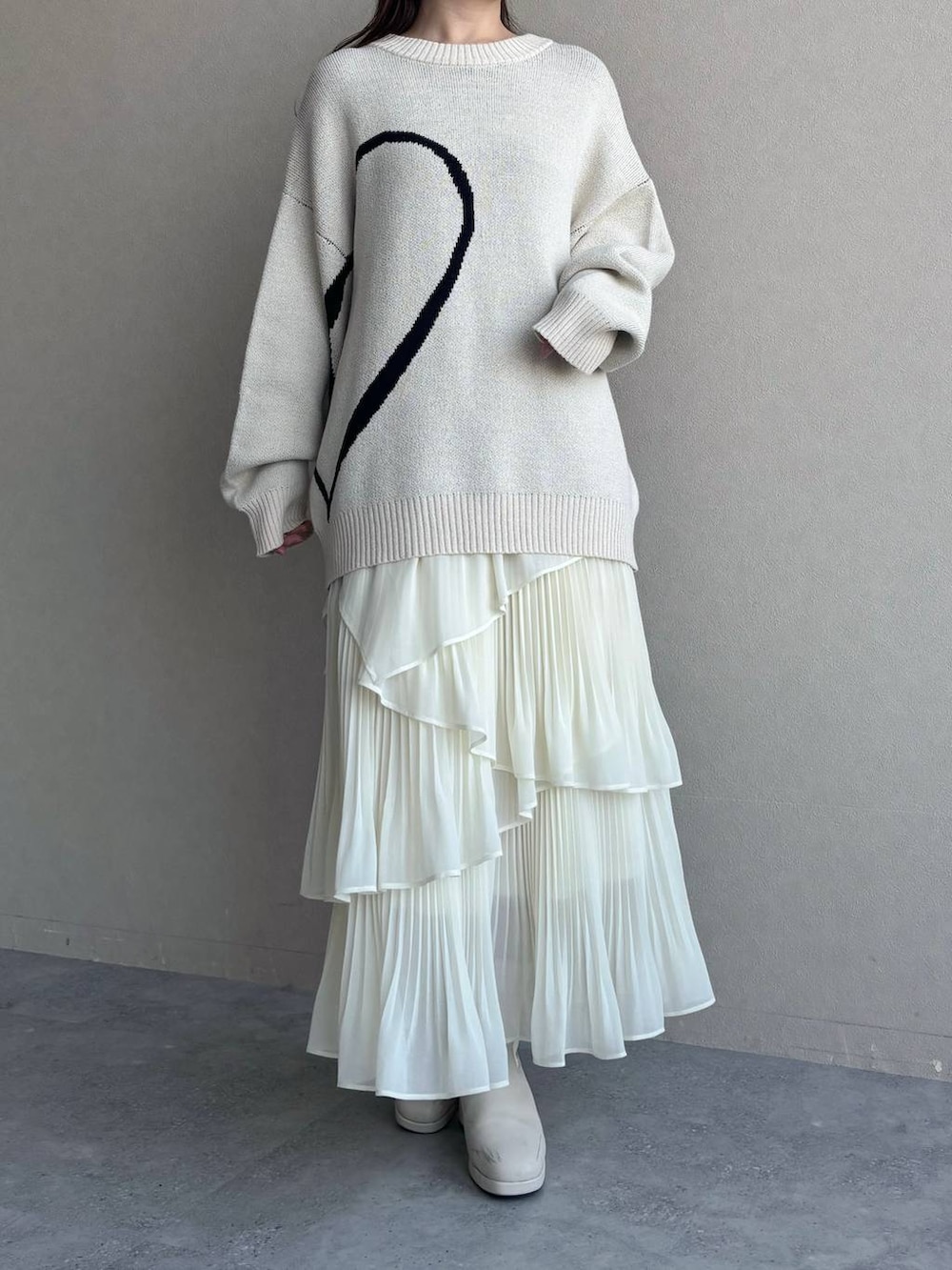 ピンク系のショルダーバッグ、ホワイト系のブーツ、ホワイト系のスカートを着用したレディースの冬コーディネートの4枚目の写真