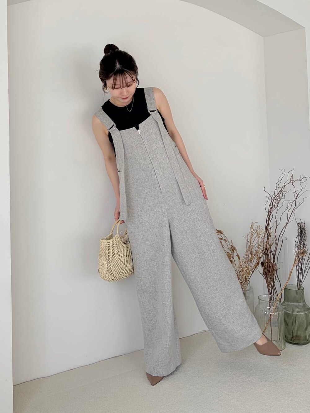 ブラウン系のサンダル、ブラック系のベスト、グレー系のサロペット/オーバーオールを着用したレディースの春コーディネートの4枚目の写真