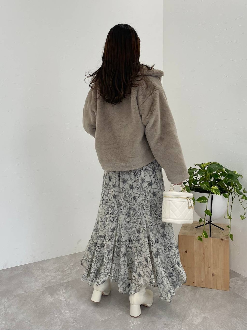 ホワイト系のブーツ、ベージュ系のスカート、ホワイト系のショルダーバッグを着用したレディースの冬コーディネートの2枚目の写真