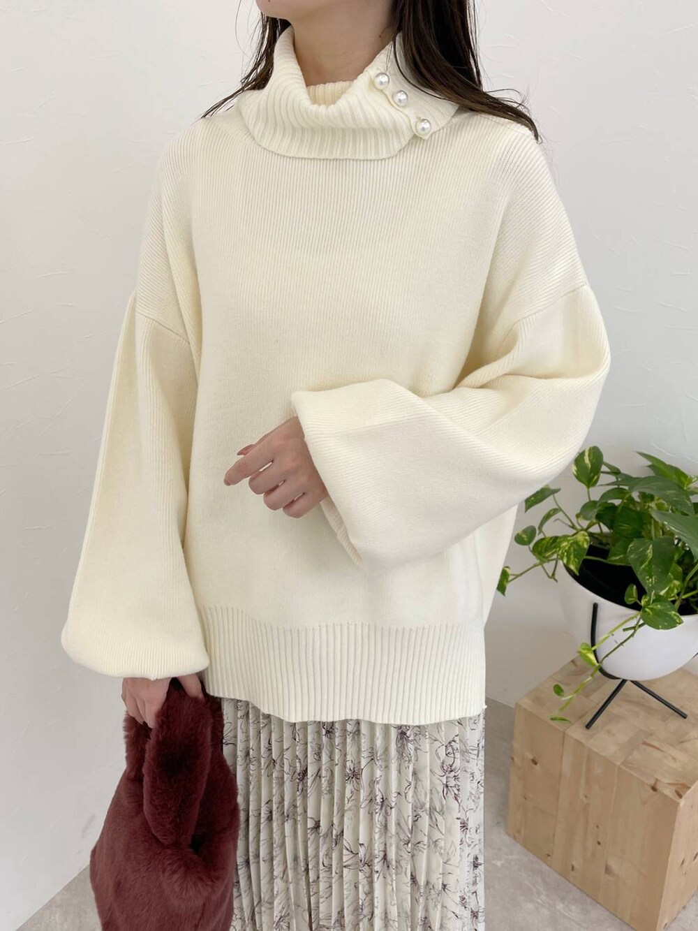 グレー系のブーツ、ピンク系のハンドバッグ、ホワイト系のスカートを着用したレディースの冬コーディネートの4枚目の写真