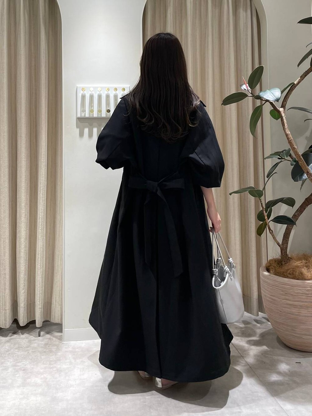 シルバー系のバレエシューズ、グリーン系のカーディガン/ボレロ、ホワイト系のスカートを着用したレディースの春コーディネートの2枚目の写真