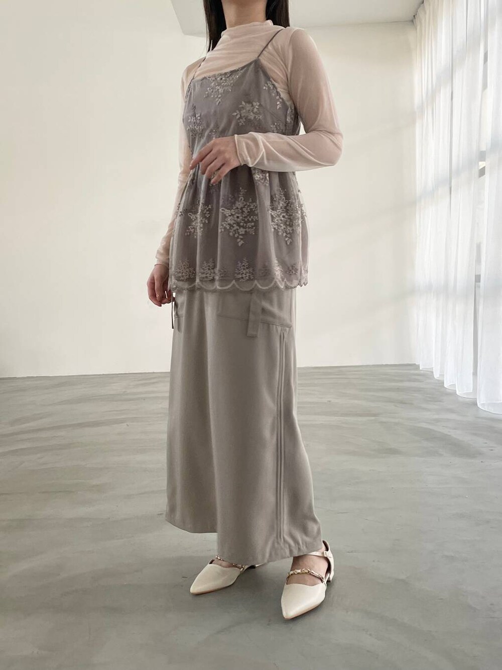 ベージュ系のスカート、ホワイト系のパンプス、ホワイト系のTシャツ/カットソーを着用したレディースの春コーディネートの2枚目の写真