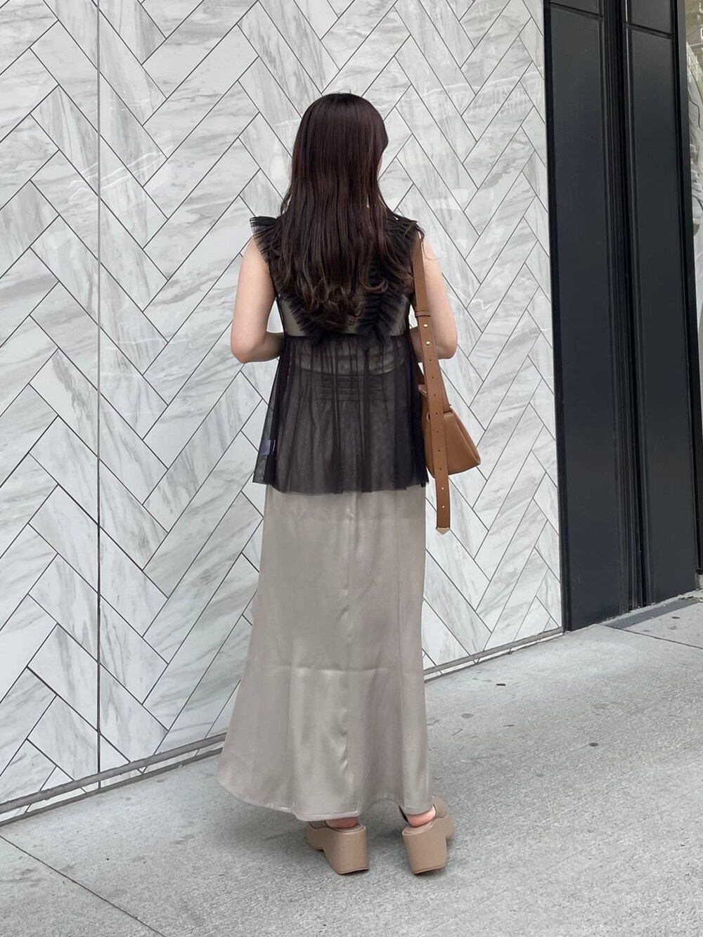 ホワイト系のキャミソール、ベージュ系のサンダル、ブラウン系のショルダーバッグを着用したレディースの夏コーディネートの2枚目の写真